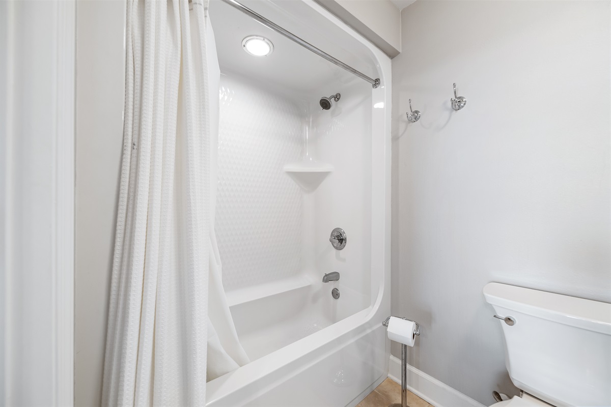 Freshly updated bathroom featuring a shower/tub combination, ample vanity space, and modern fixtures.