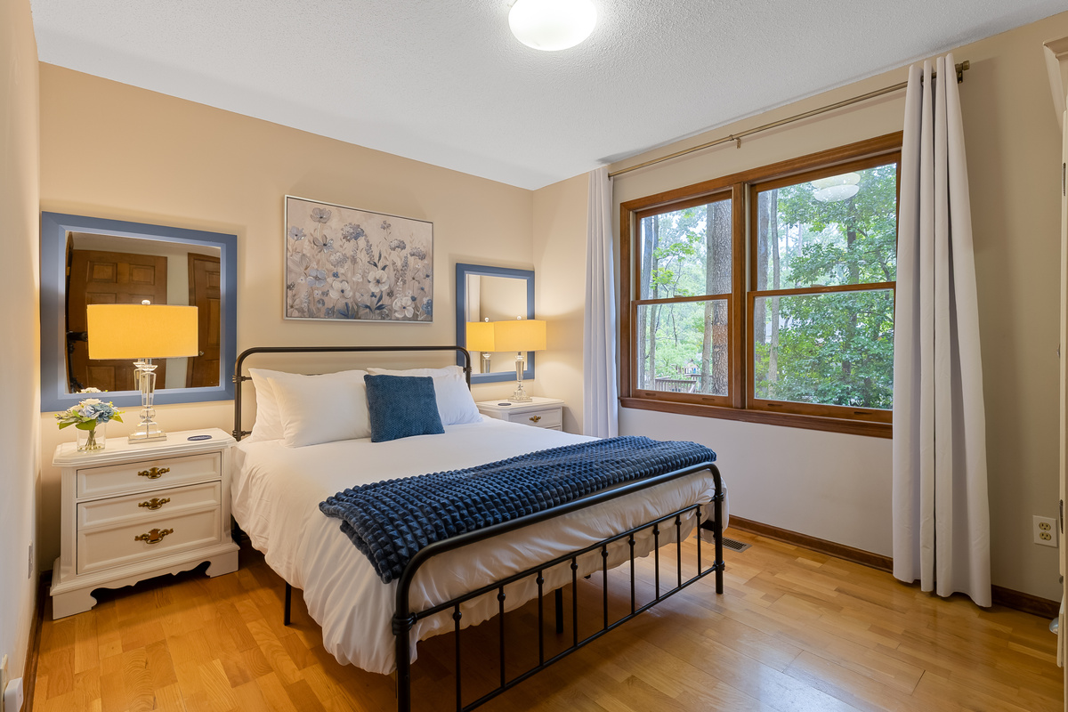 Main floor queen bedroom with views of the trees