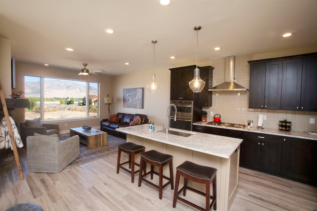 Gourmet kitchen with large island, seating, and scenic views—perfect for cooking and socializing.