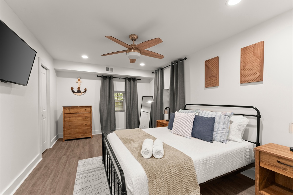 Roomy Queen bedroom downstairs with flat-screen TV.