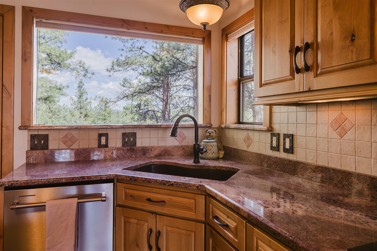 Bright kitchen with large windows that bring in natural light and mountain views.