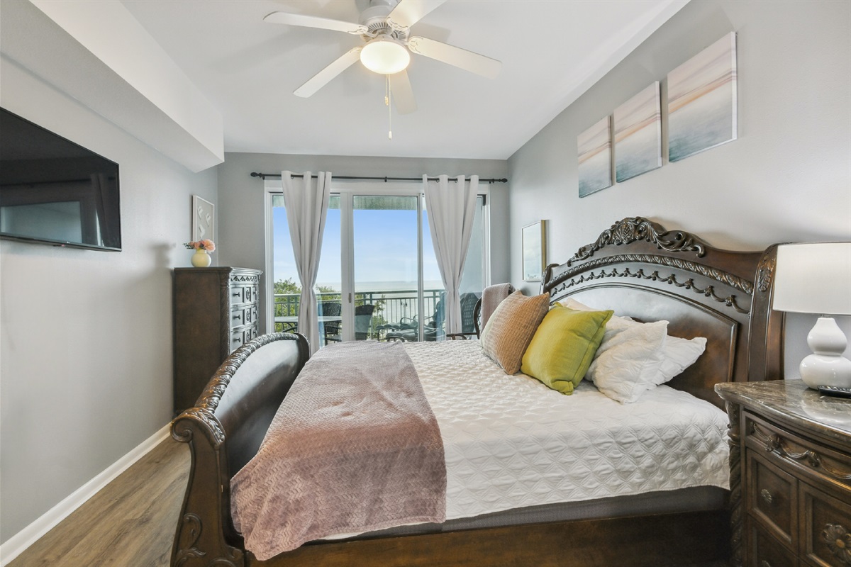 Primary bedroom with balcony access and beach view.