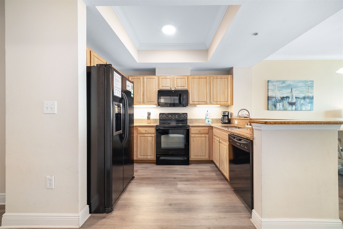 This fully functional kitchen boasts stainless steel appliances, sleek countertops, and ample cabinet storage, ideal for everyday cooking and entertaining.