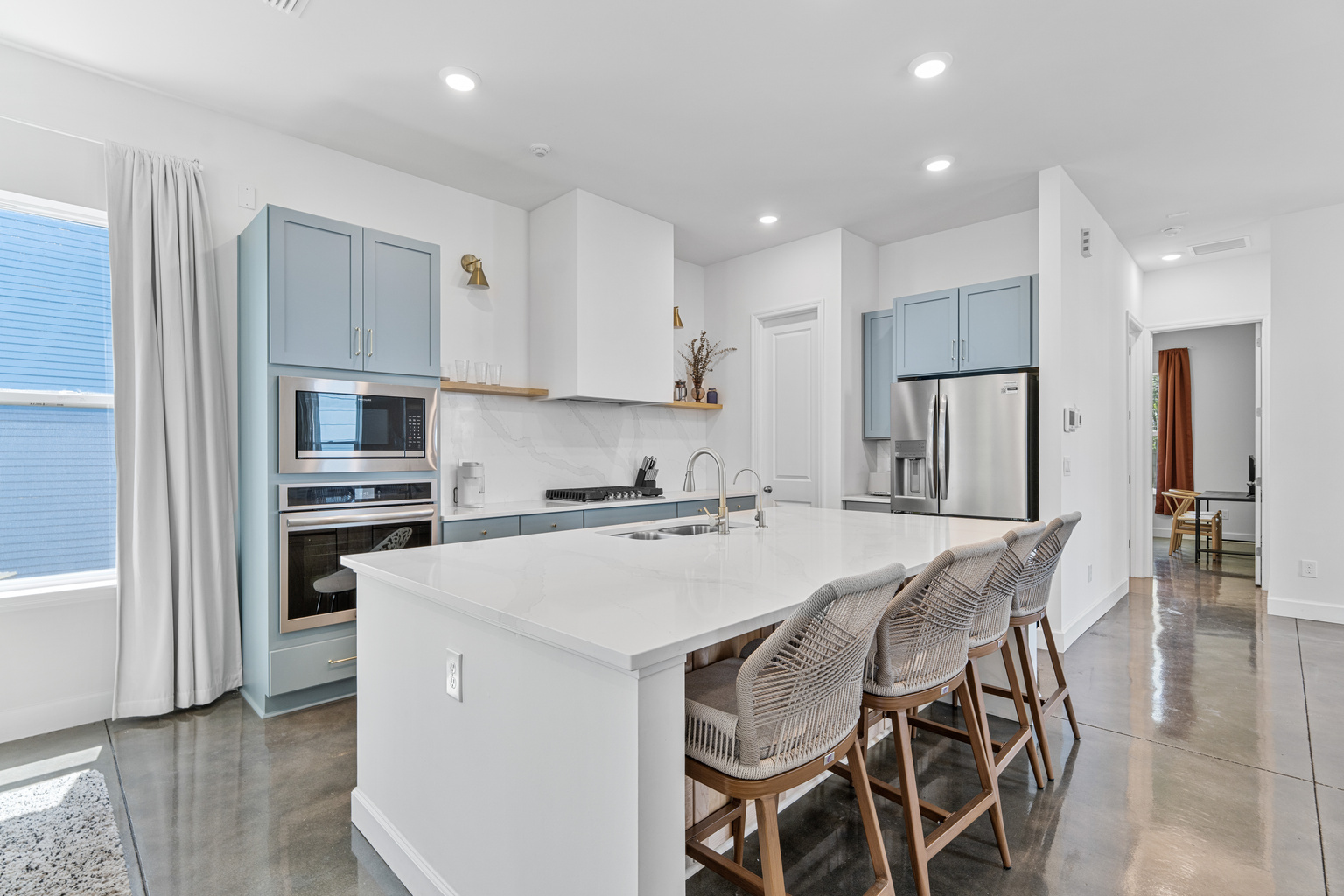 Gather around the island while someone flips pancakes and the coffee goes on. With seating for four and room for helpers, this is where your mornings start slow and your evenings run long, everyone talking over everyone else.