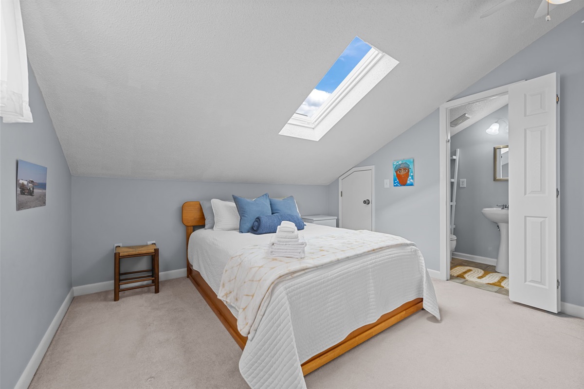 Bright loft bedroom with a Queen bed, soft linens, and natural light from the skylight&mdash;airy, calm, and inviting