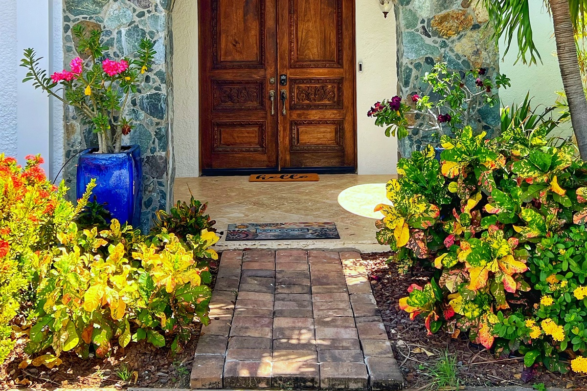 Welcome home with vibrant tropical blooms at the entrance.