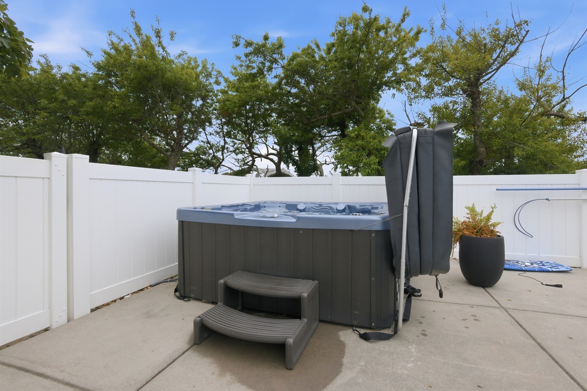 Outdoor hot tub area with privacy fencing and easy poolside access.