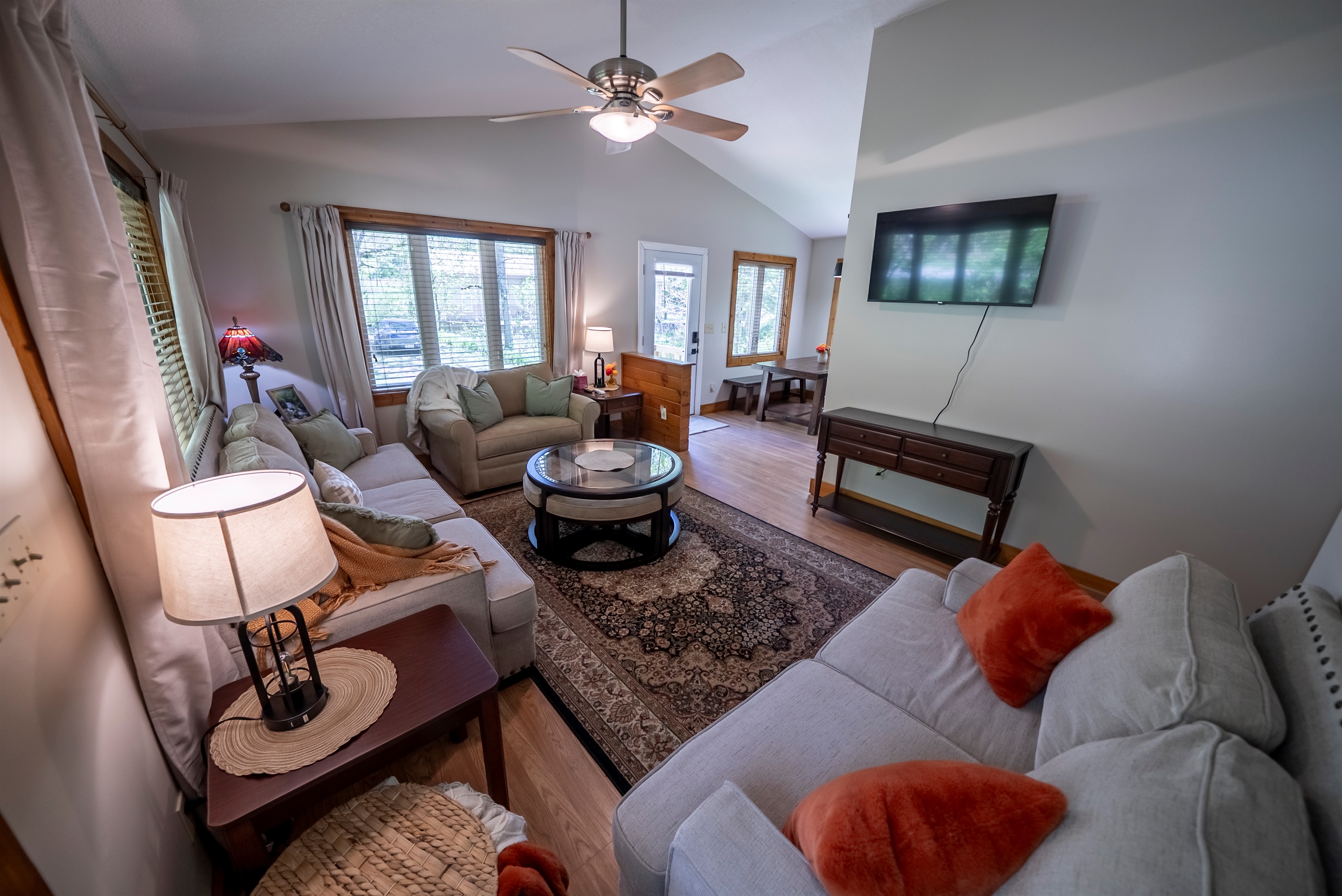 Comfortable living space with a Smart TV, couch, loveseat, and oversized chair that converts to a twin bed, plus a coffee table with hidden seating perfect for game night.