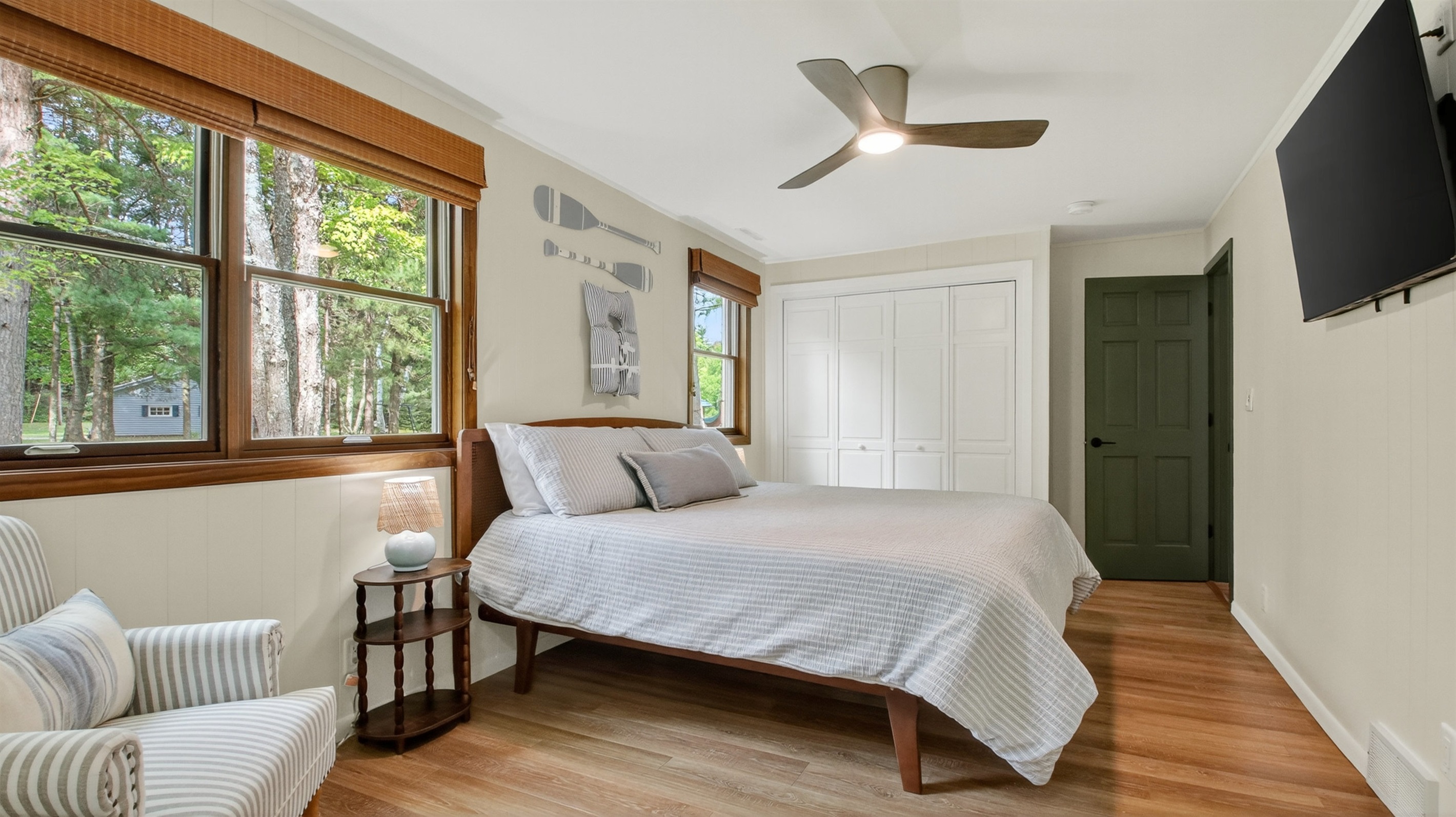 The primary bedroom has a king bed and closet with drawers and hanging rods for clothing storage.