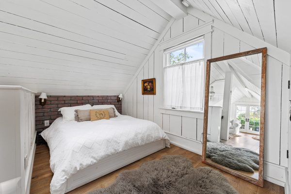 The mattress guests keep asking about! Tucked beneath the eaves, this dreamy upstairs bedroom pairs an eco queen mattress with soft white linens, warm wood and bedside reading lights—a cozy end to any day in the valley.
