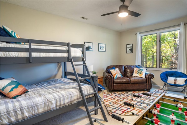 Twin-over-full bunk room, also featuring a foosball table and sitting area around big-screen TV.   