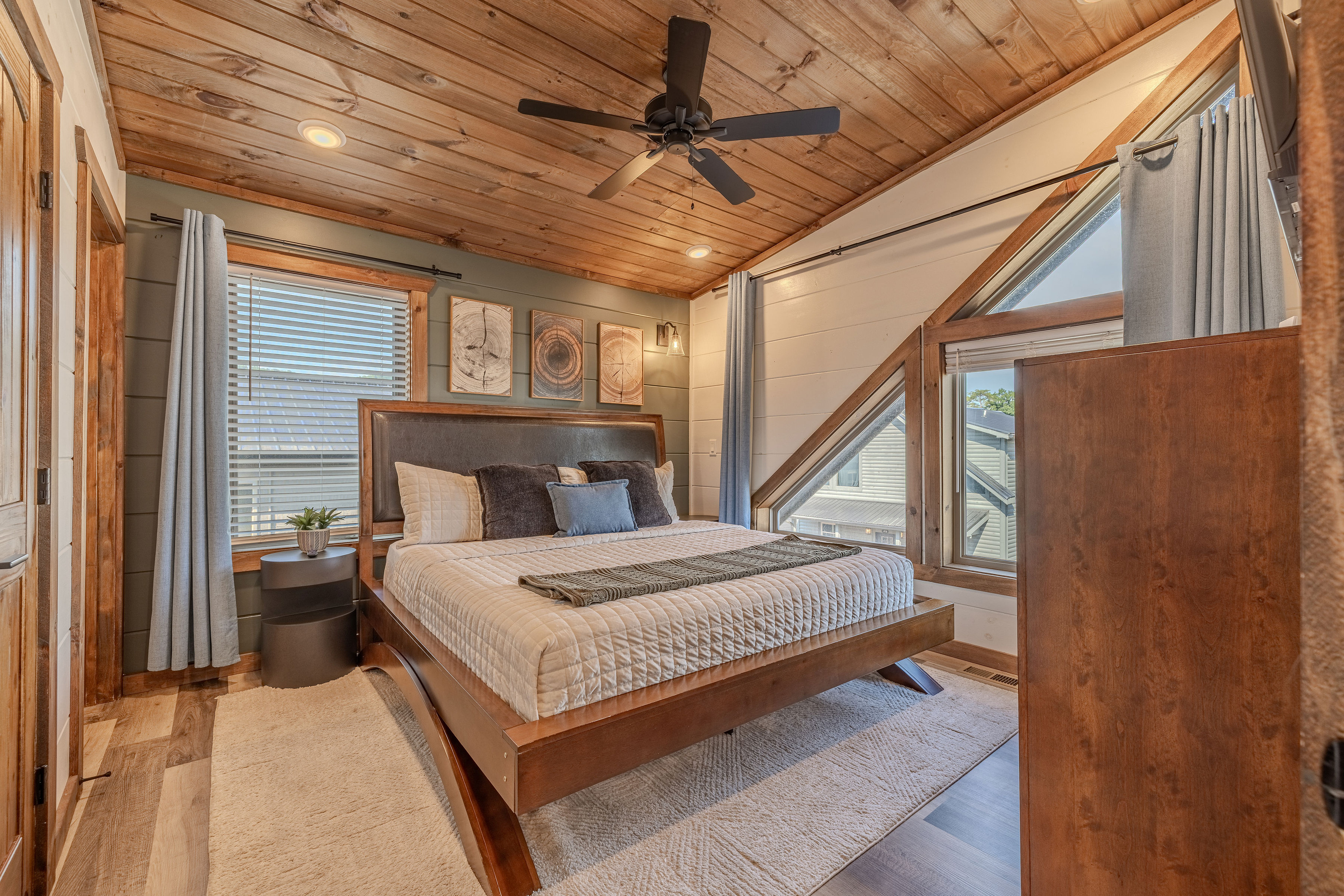 King bedroom with warm wood ceilings and abundant natural light and blackout curtains.