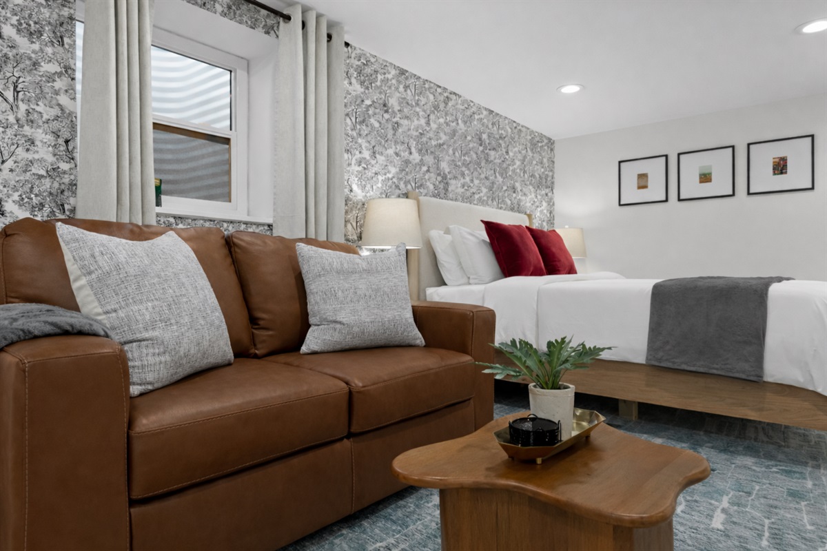 Relax in a cozy, well-styled studio featuring a comfortable seating area, crisp linens, warm lighting, and a calming, modern design.
