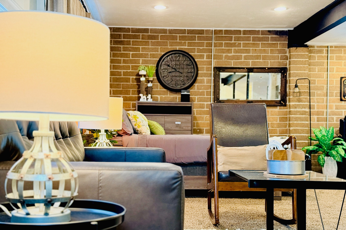 Comfortable living area with a sofa, rocker chair, side tables, and warm lighting.