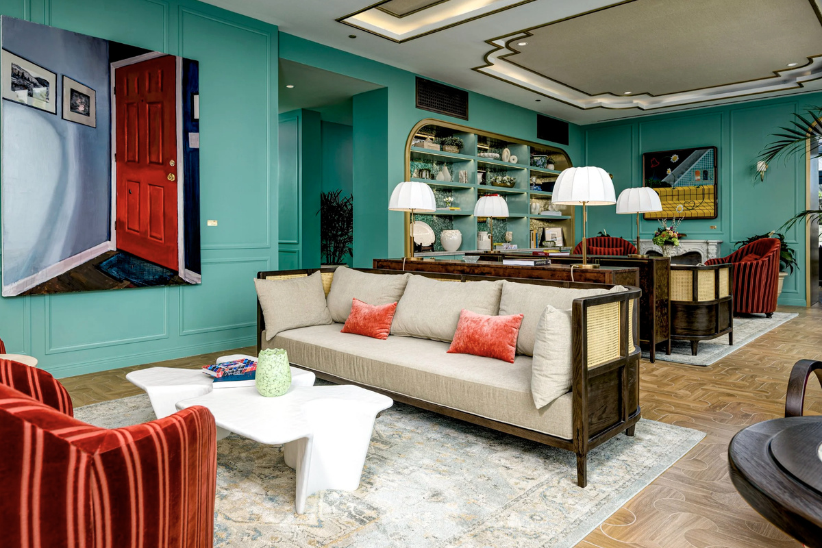 A designer salon in soft teal with sculptural coral seating - an elegant space to gather or unwind.