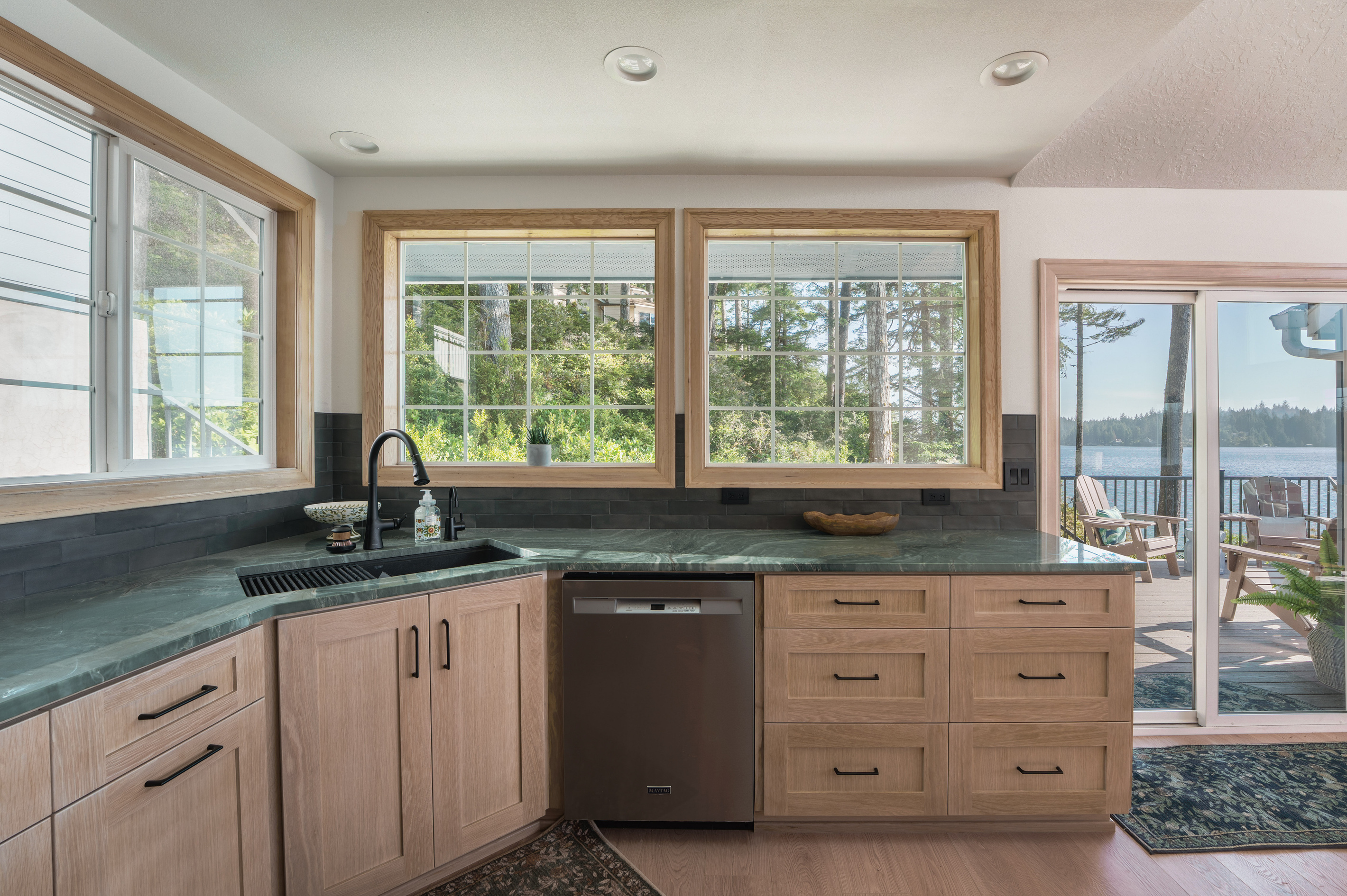 Fully equipped kitchen with modern appliances, generous counter space, and large windows that fill the room with natural light. Coffee station includes Keurig k-cup pods and traditional ground coffee maker