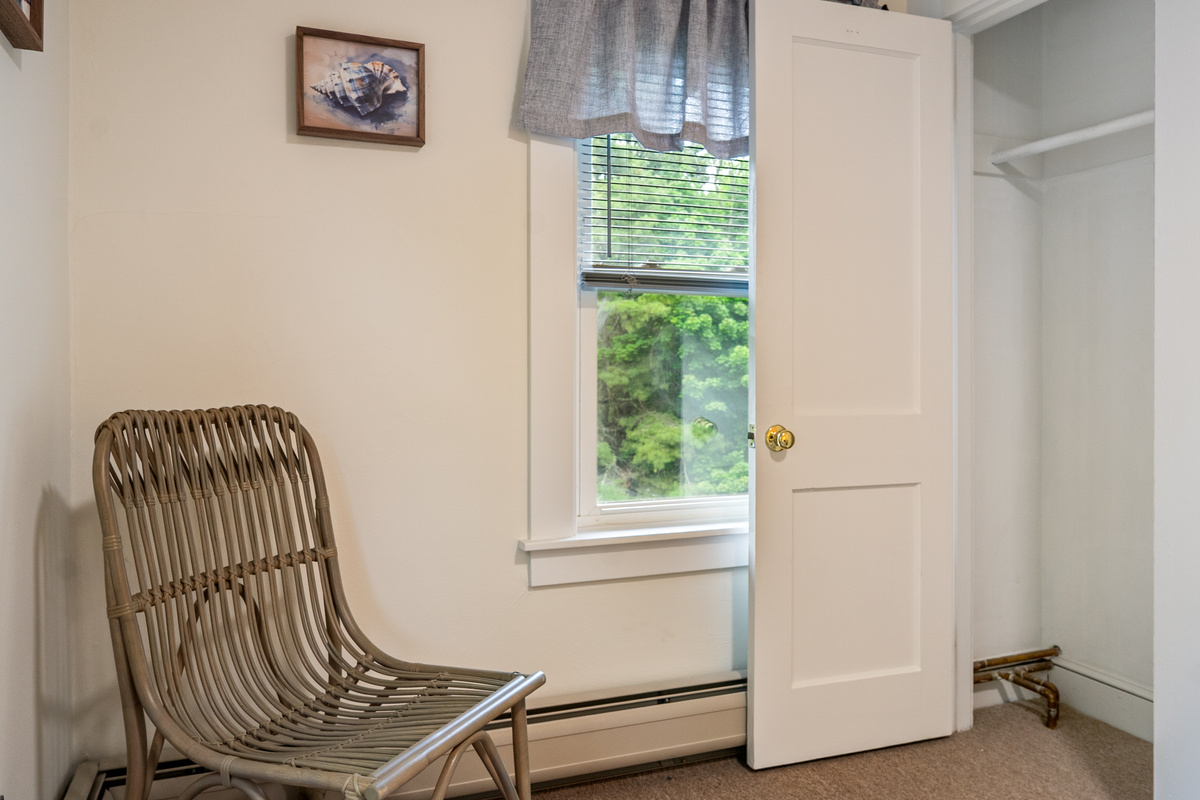 This layout perspective showcases the functional closet storage and accent seating inside the second-floor full room. By keeping your luggage and wardrobe organized out of the main walking path, the space remains open, clean, and restful.