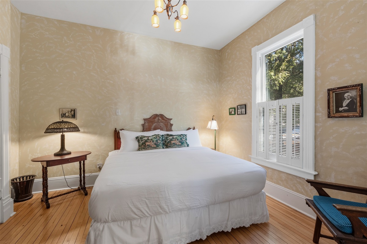 King bedroom on main floor w/ bright windows & classic furnishings