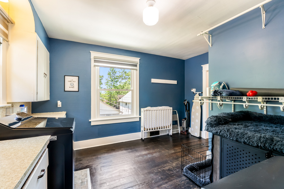 Fully equipped upper-floor laundry room featuring a large-capacity washer and dryer, iron, and a dedicated pet station with 2 crates for our four-legged guests.