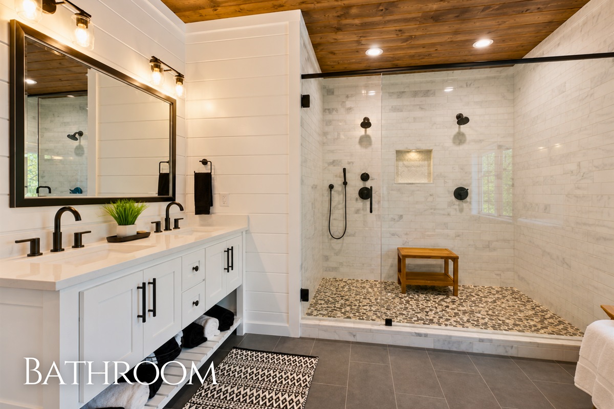 The spa-inspired bathroom features a large walk-in glass shower, modern finishes, and plenty of room to refresh and unwind.