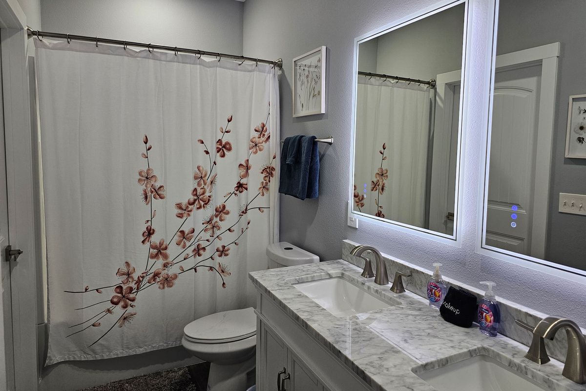 Bright, updated bathroom with modern vanity and spacious shower/tub combo.
