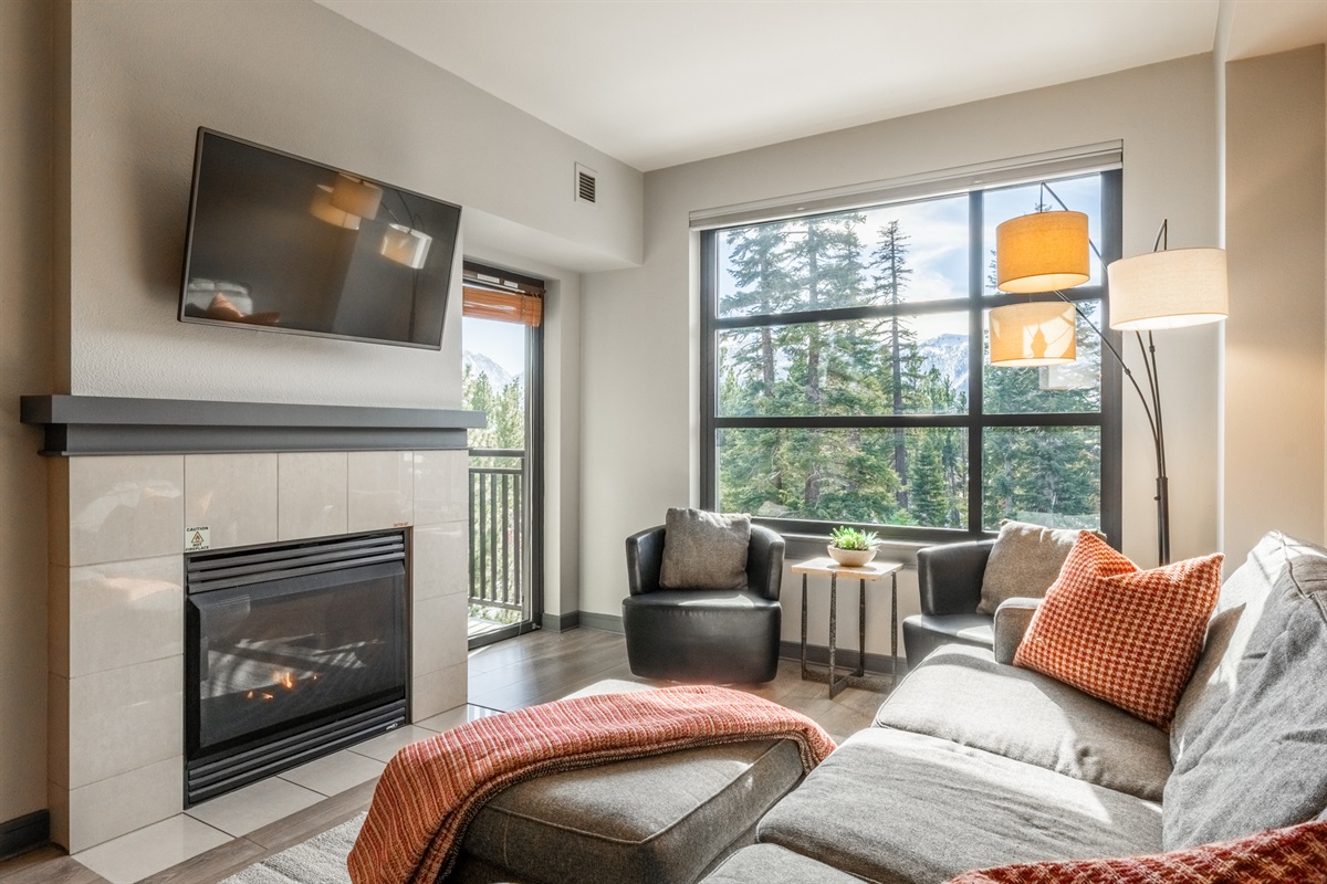 Mammoth Mosaic offers a sunlit living space anchored by a cozy fireplace and mountain views.