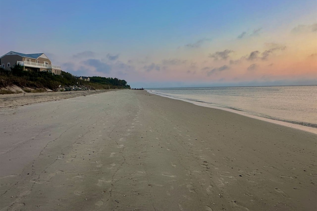 Take a sunset stroll on this quiet, expansive beach just a block from your door. The soft sand and calm morning tide create a serene, private atmosphere perfect for your peaceful coastal getaway.