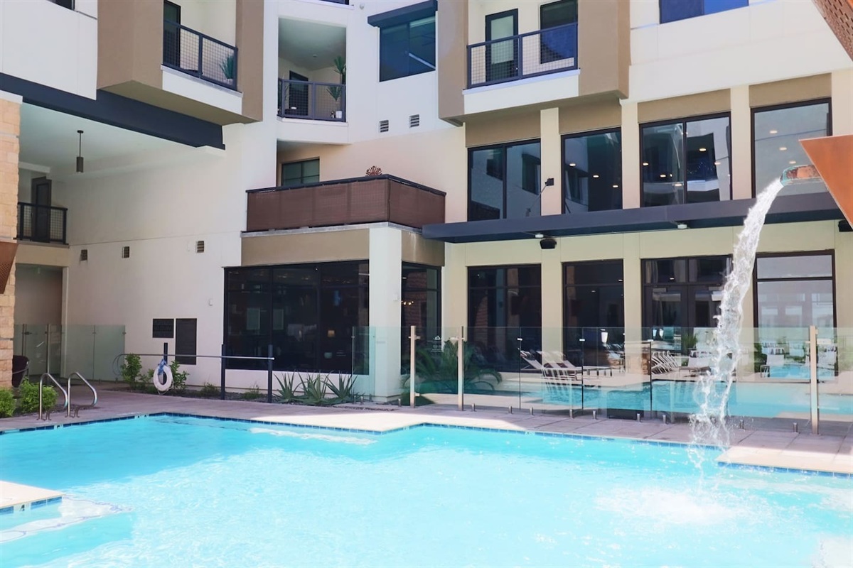 - Dive into a sparkling pool with cascading water features and sunny views   - Surrounded by modern architecture and inviting outdoor lounge seating   - A refreshing retreat to relax, swim, and enjoy peaceful summer moments