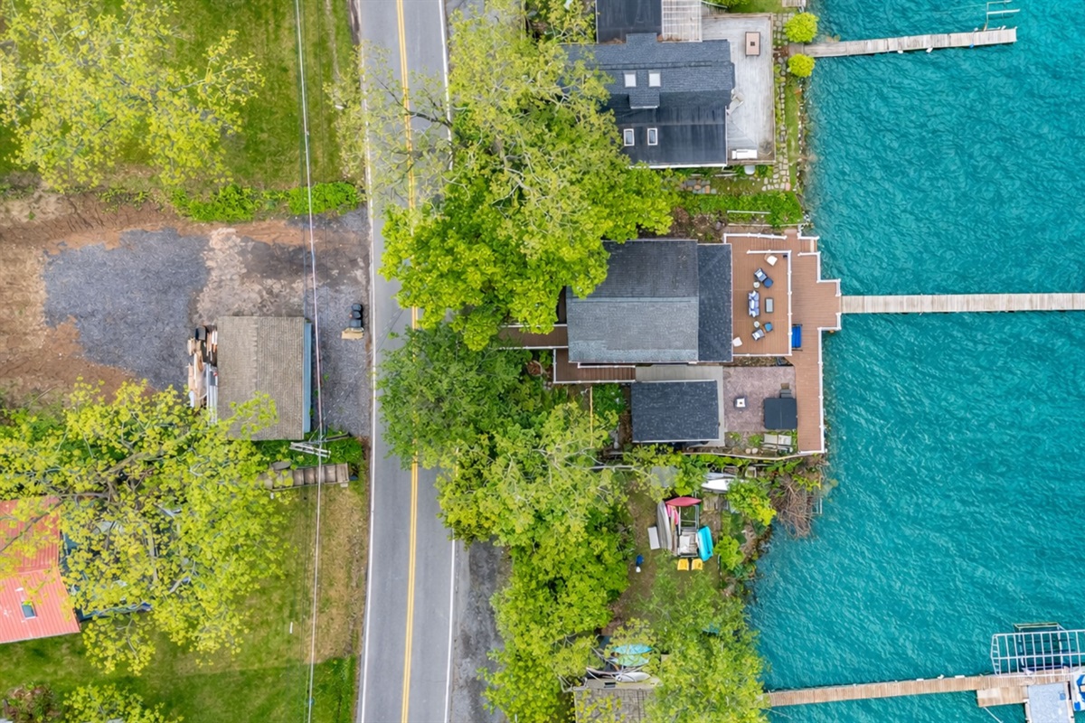 Aerial shot showcasing expansive lakefront entertaining space, hot tub, and private dock for the ultimate getaway 🎯🌊🍹