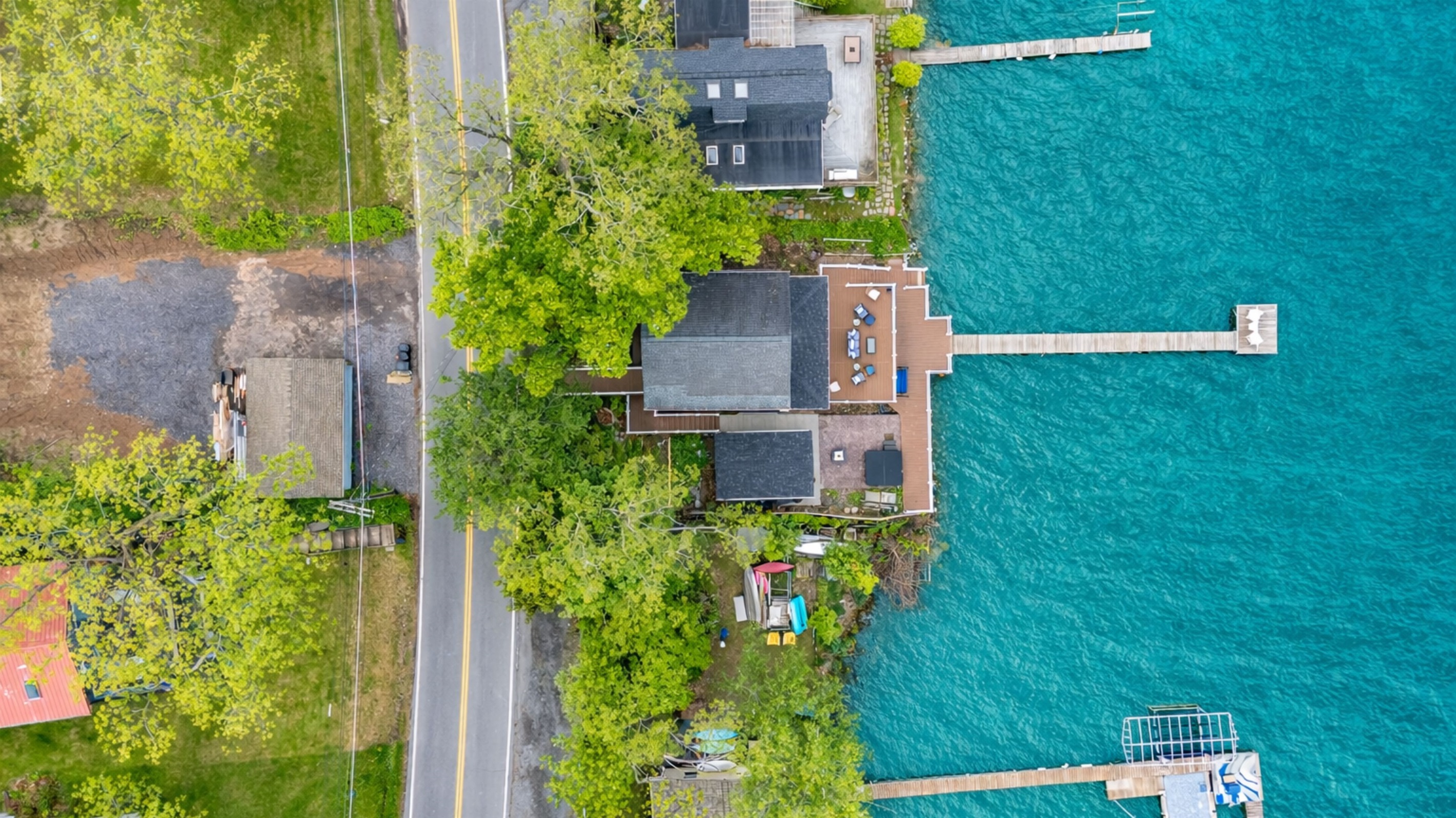 Aerial shot showcasing expansive lakefront entertaining space, hot tub, and private dock for the ultimate getaway 🎯🌊🍹