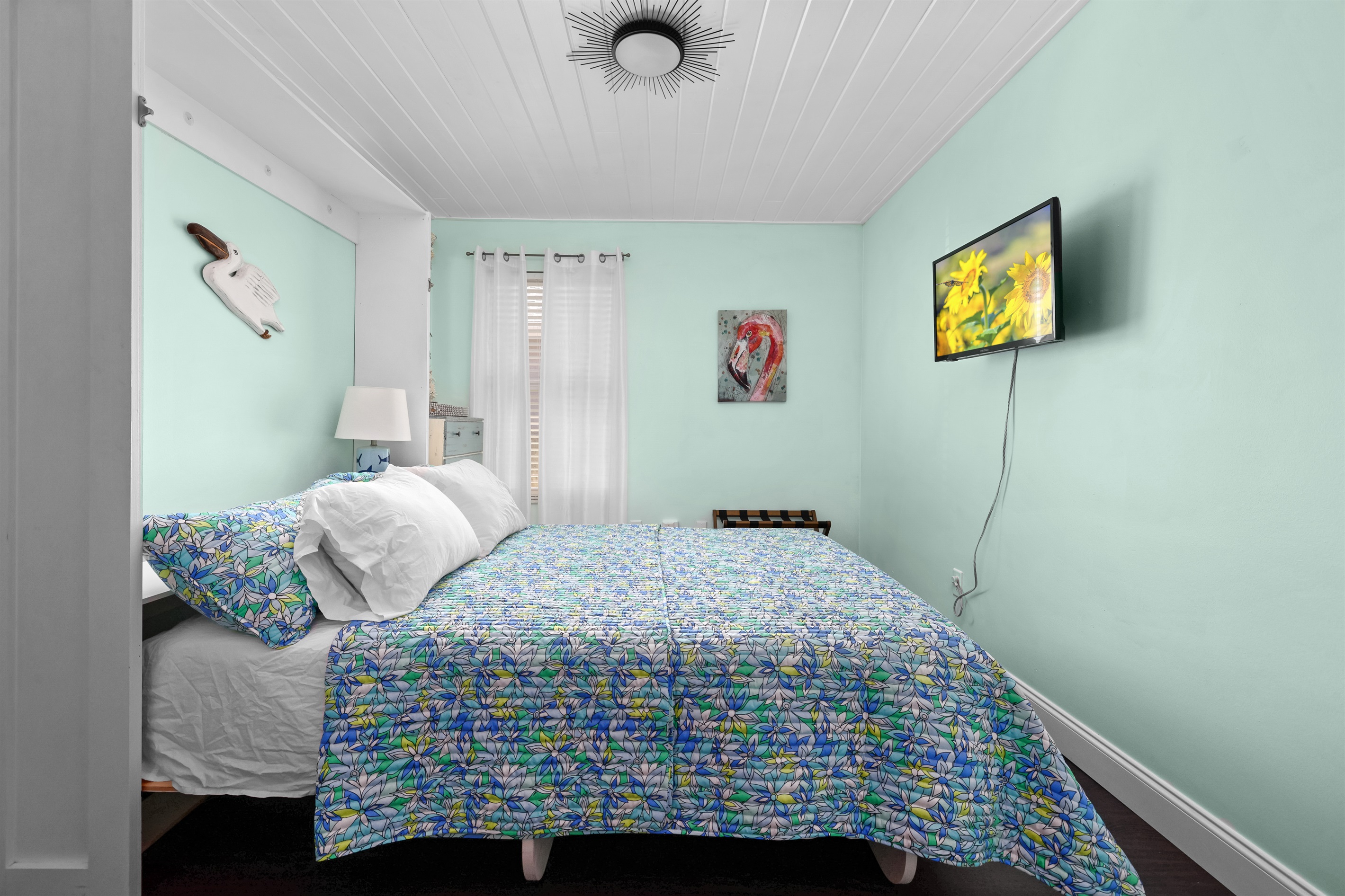 This bright, tropical bedroom has comfy bedding perfect for a good night's sleep.