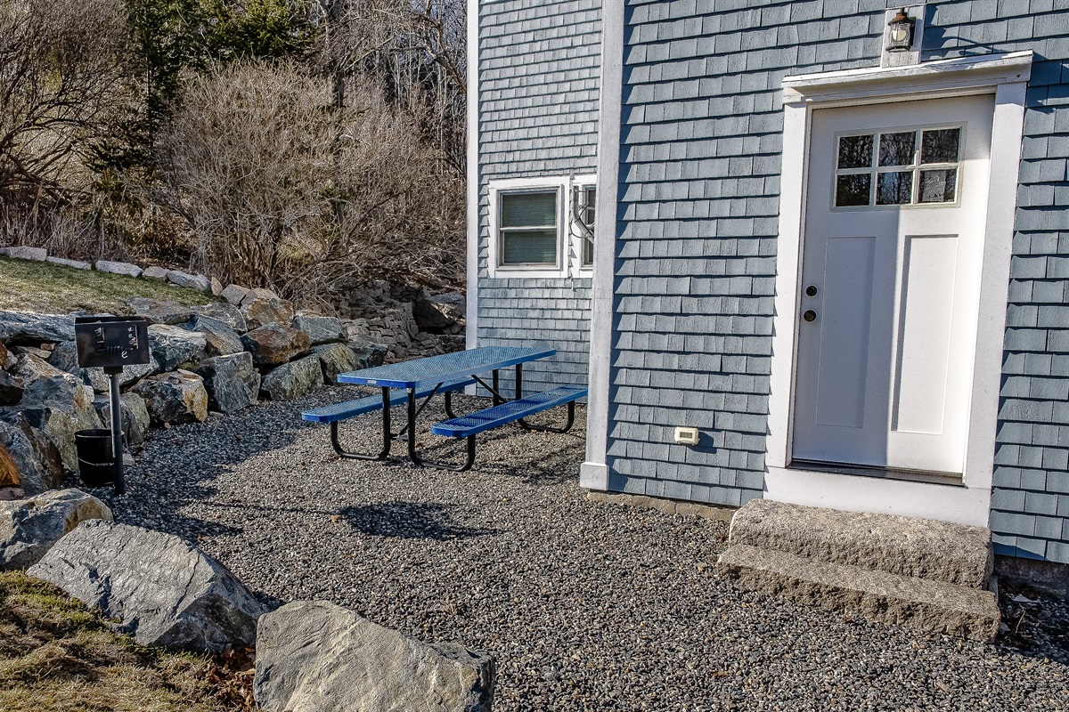 The outdoor grill area is just steps from the kitchen door, making it easy to prep and serve your favorite trailside meals. This convenient setup, framed by Maine granite, ensures you spend less time in the kitchen and more time enjoying the island air.