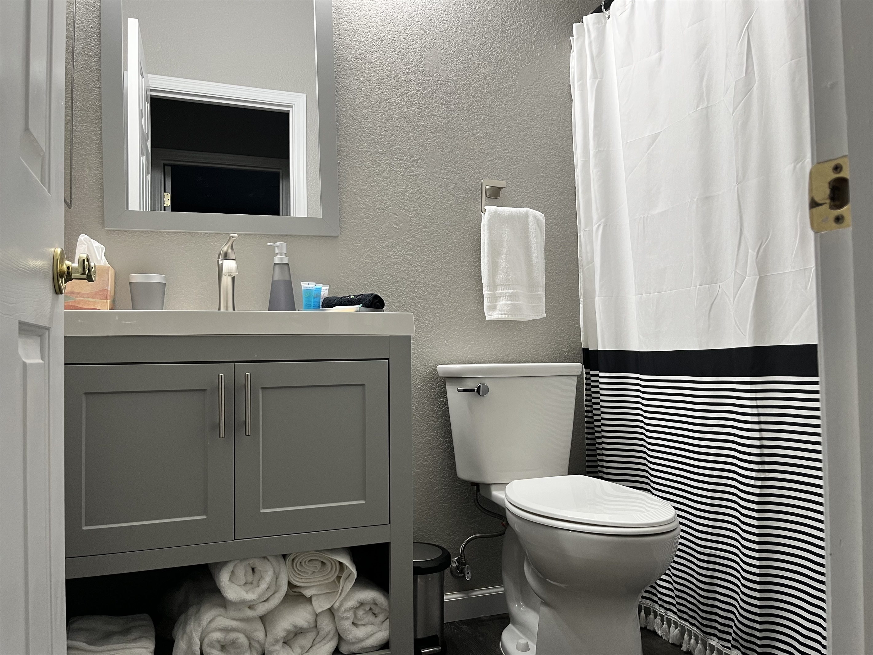 Clean and modern shared bathroom with tub/shower combo, fresh towels, and all the essentials for a comfortable stay. 