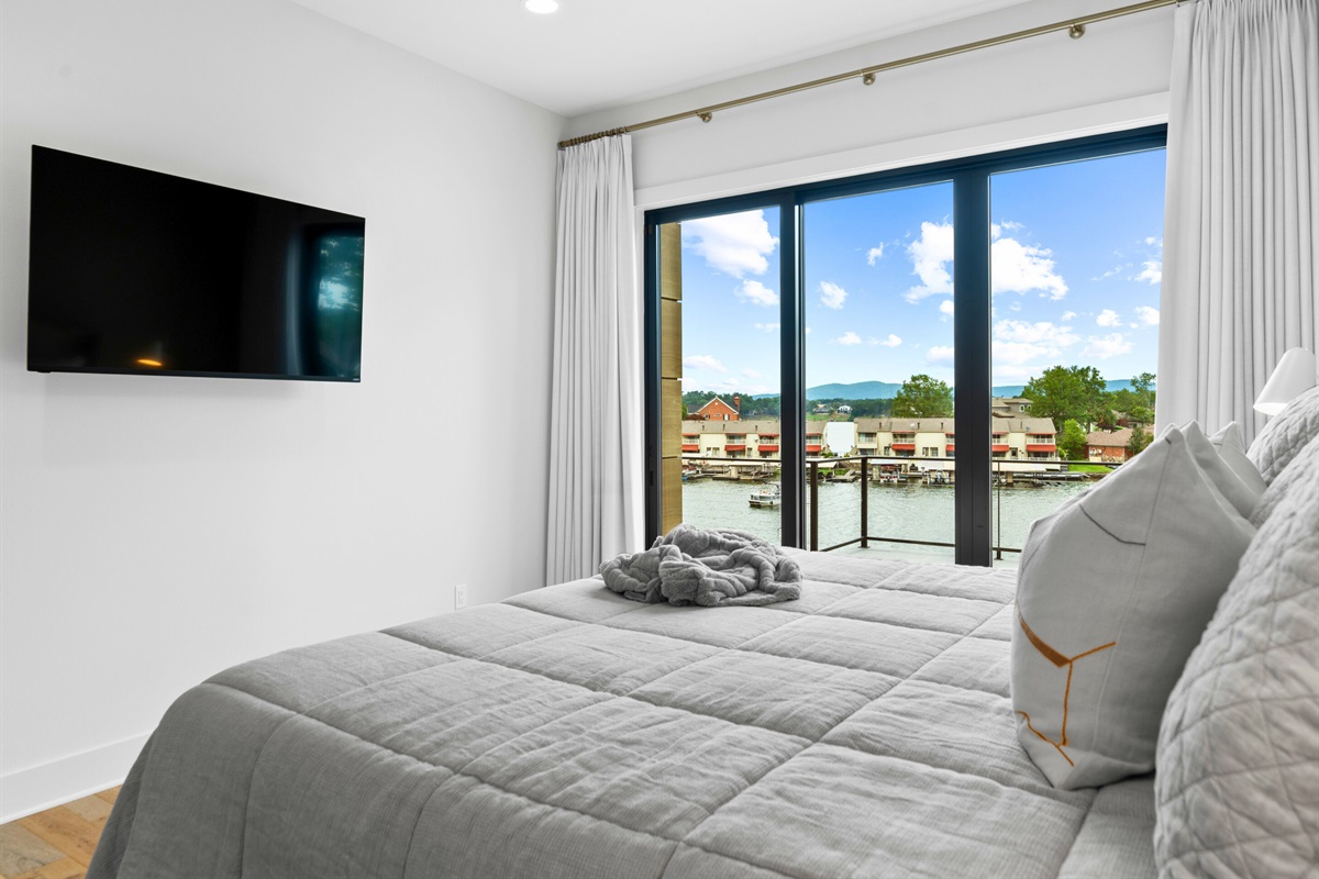 The serene decor and large windows in this king bedroom create a peaceful and inviting atmosphere.