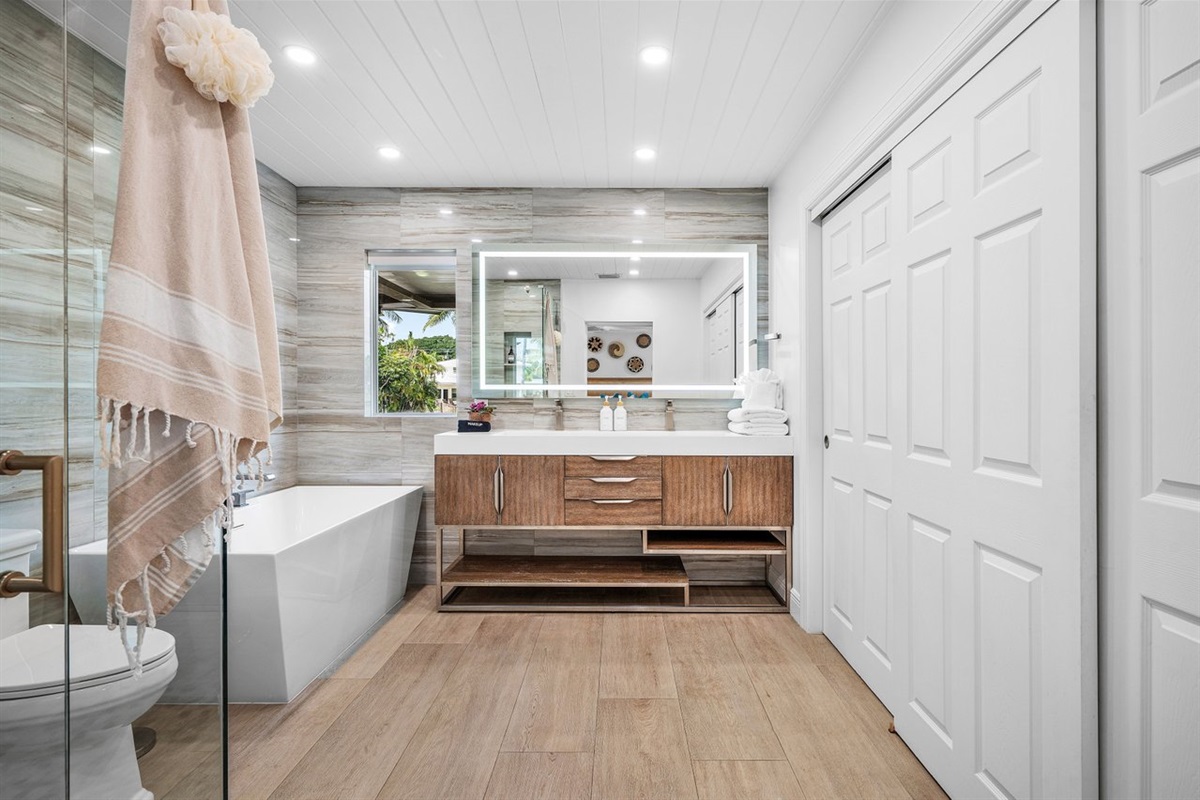 A calming retreat for everyday indulgence, the spacious layout pairs a soaking tub with elegant finishes and soft coastal textures.