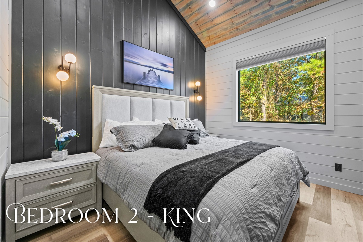 This inviting king suite offers a calm escape, complete with a rich accent wall, modern lighting, and soft linens that make you want to linger longer.