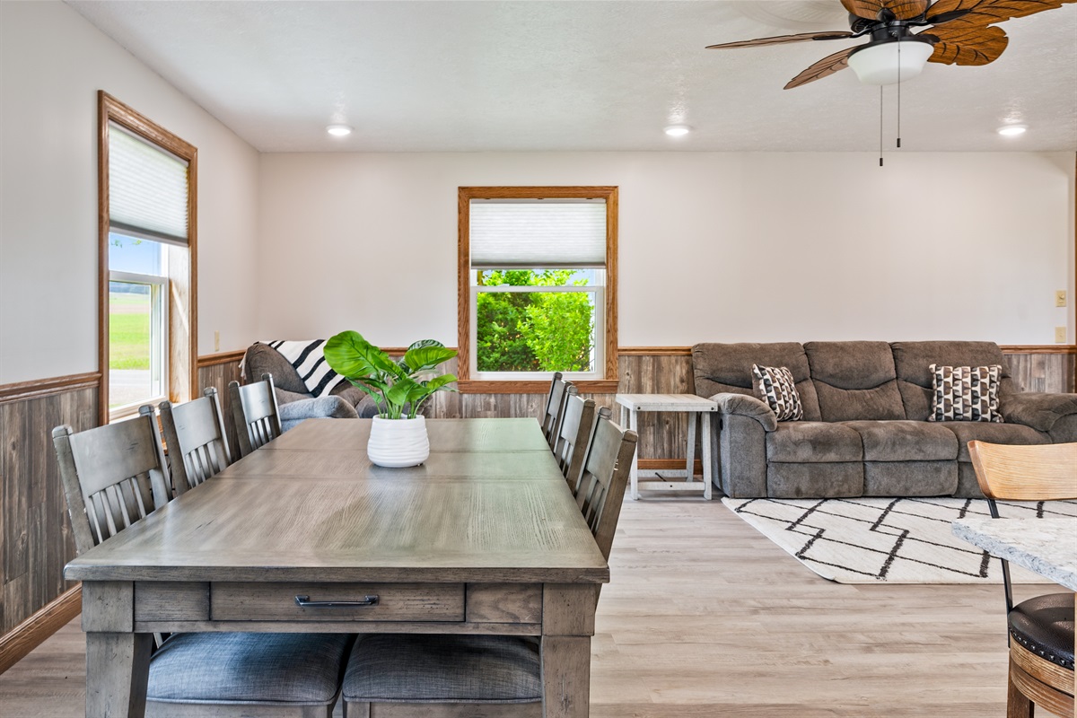 Enjoy meals with a view in this bright dining area featuring large windows, rustic wood accents, and cozy seating for six.