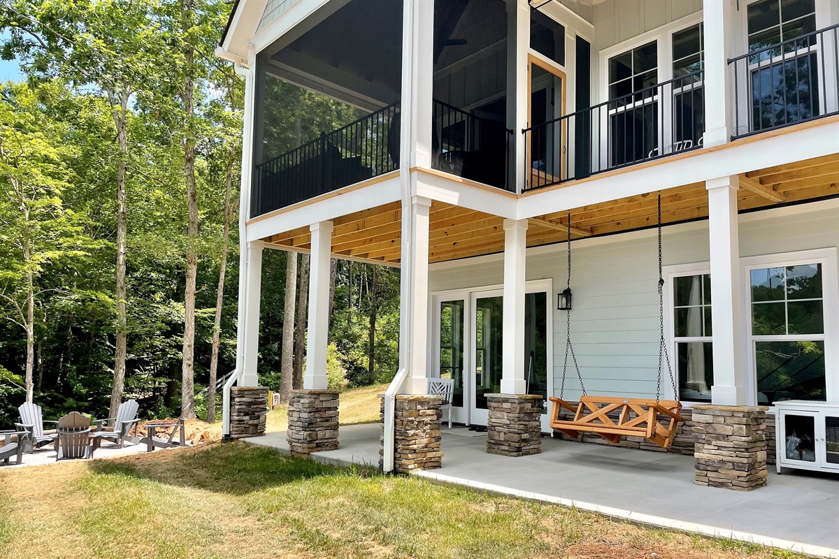 Lower level has a table, swing, gas and charcoal grills, outdoor shower, fire pit and small back yard