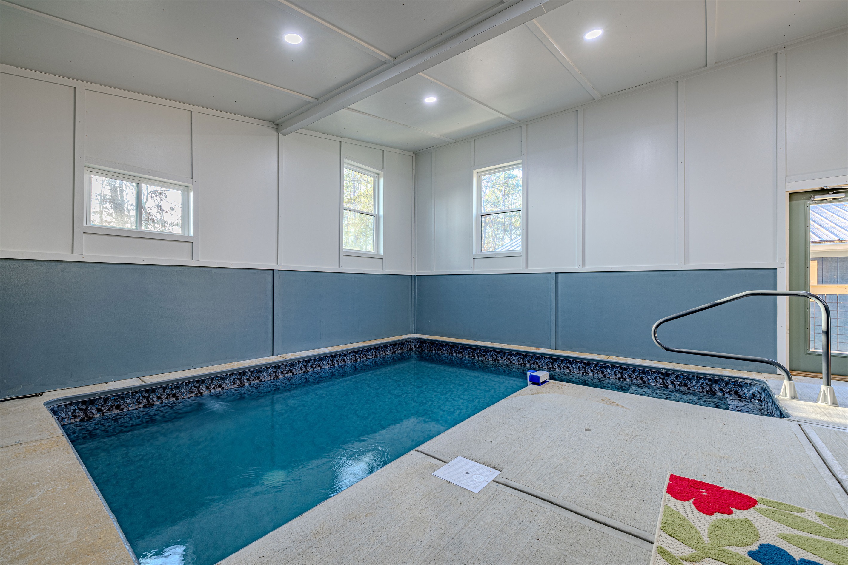 The pool’s deep blue tiling perfectly complements the cabin's signature mid-century modern color palette and aesthetic.