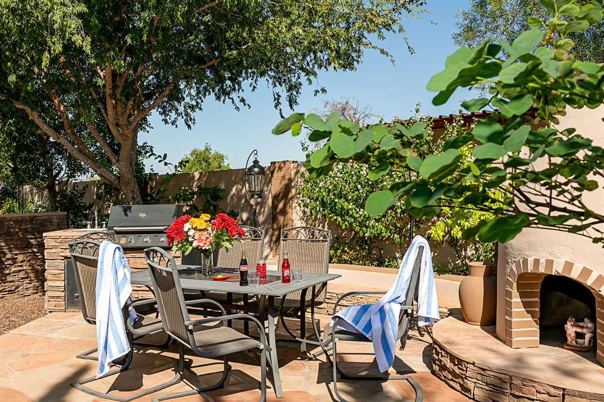 Enjoy alfresco meals in a vibrant garden setting, complete with a grill and shaded table perfect for post-swim gatherings or sunset dinners.