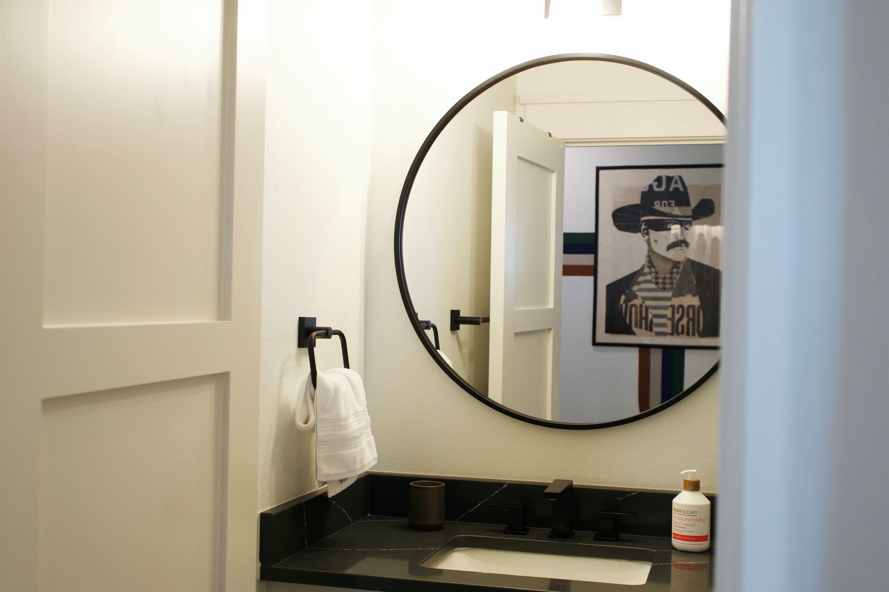 Sleek vanity with ample counter space and a well-lit mirror for getting ready.