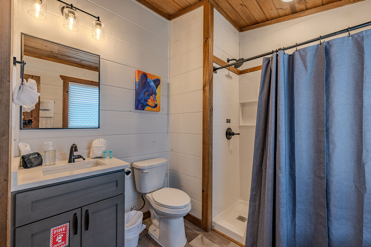 Bright full bathroom with convenient counter and storage space.