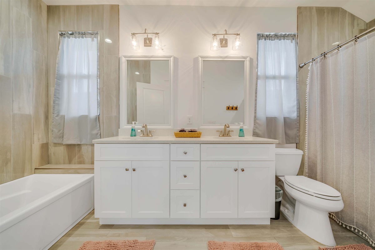 Start your morning in this bright primary bathroom. Dual sinks give two people plenty of room to get ready.