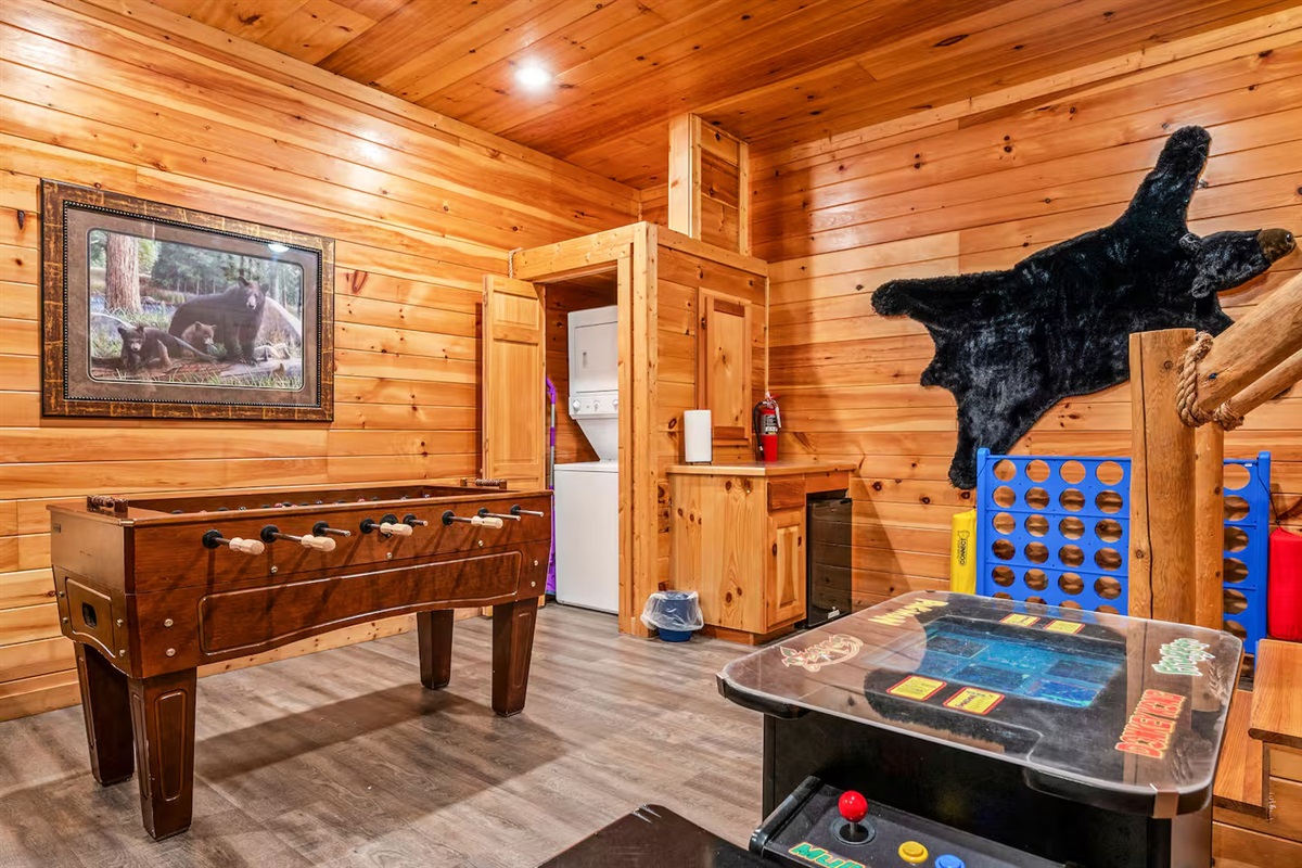 Open concept lower level game room with arcade, Foosball, TV and laundry