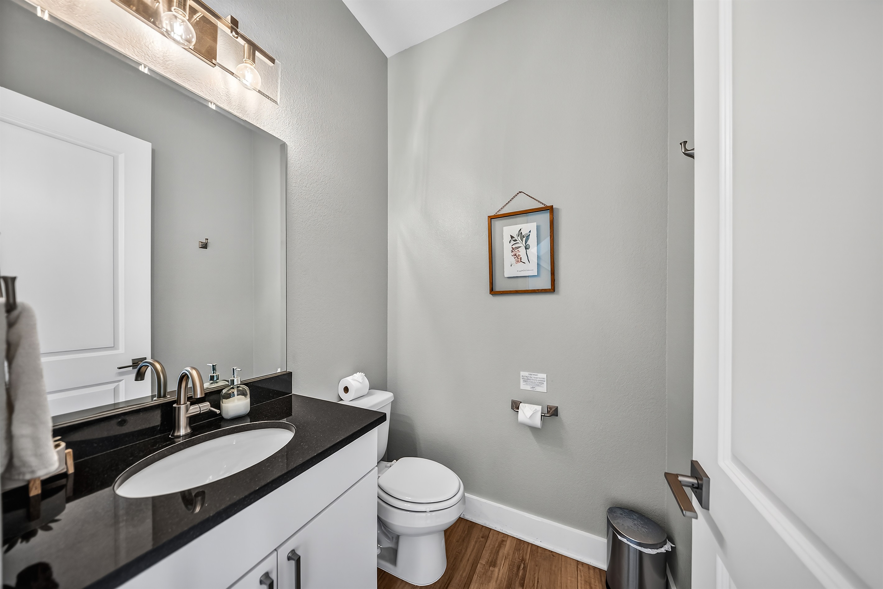 - A modern half bath with a bright vanity and a clean, refreshing style. The convenient layout accommodates families and groups during their stay.