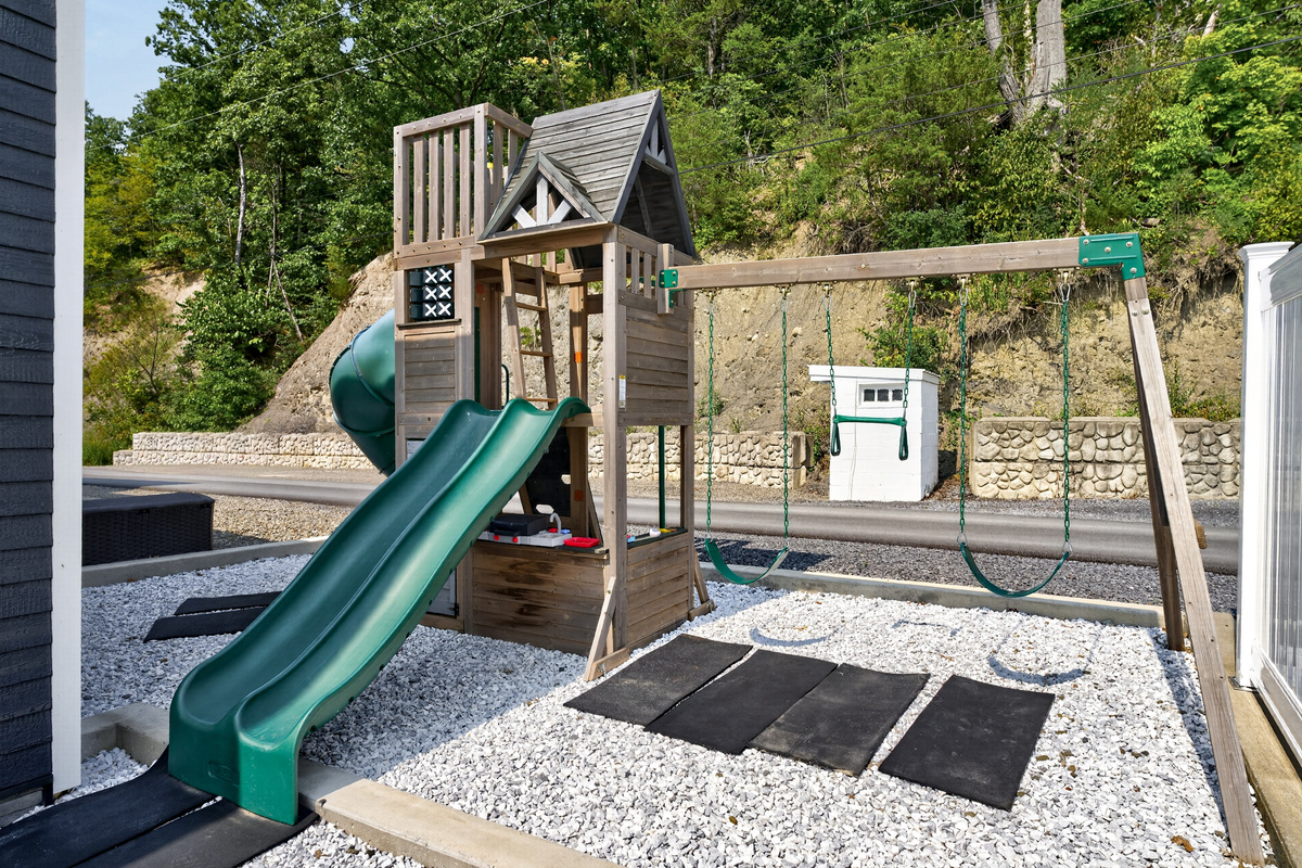Fenced play area with slide and climbing frame