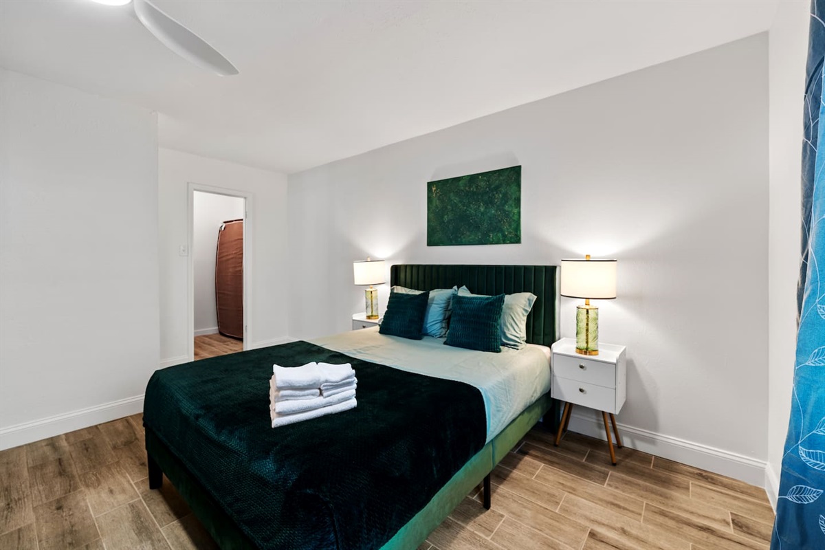 Unwind in a spacious king bed with layered pillows, dimming curtains, and bedside lighting for the perfect night’s rest.