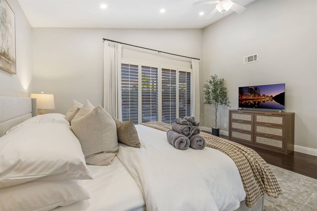 The primary bedroom features a 42" Smart TV, letting you enjoy your favorite shows while relaxing in the cozy bed. The room is thoughtfully designed sliding doors that open to the backyard, flooding the space with natural light for a serene retreat.
