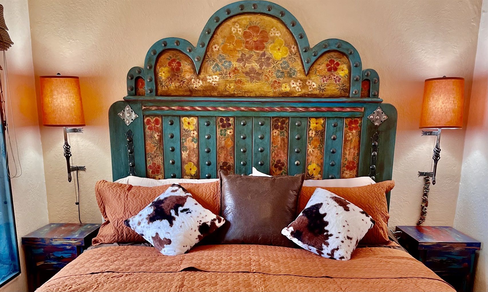 King-size bed with vibrant textiles and artistic accents.