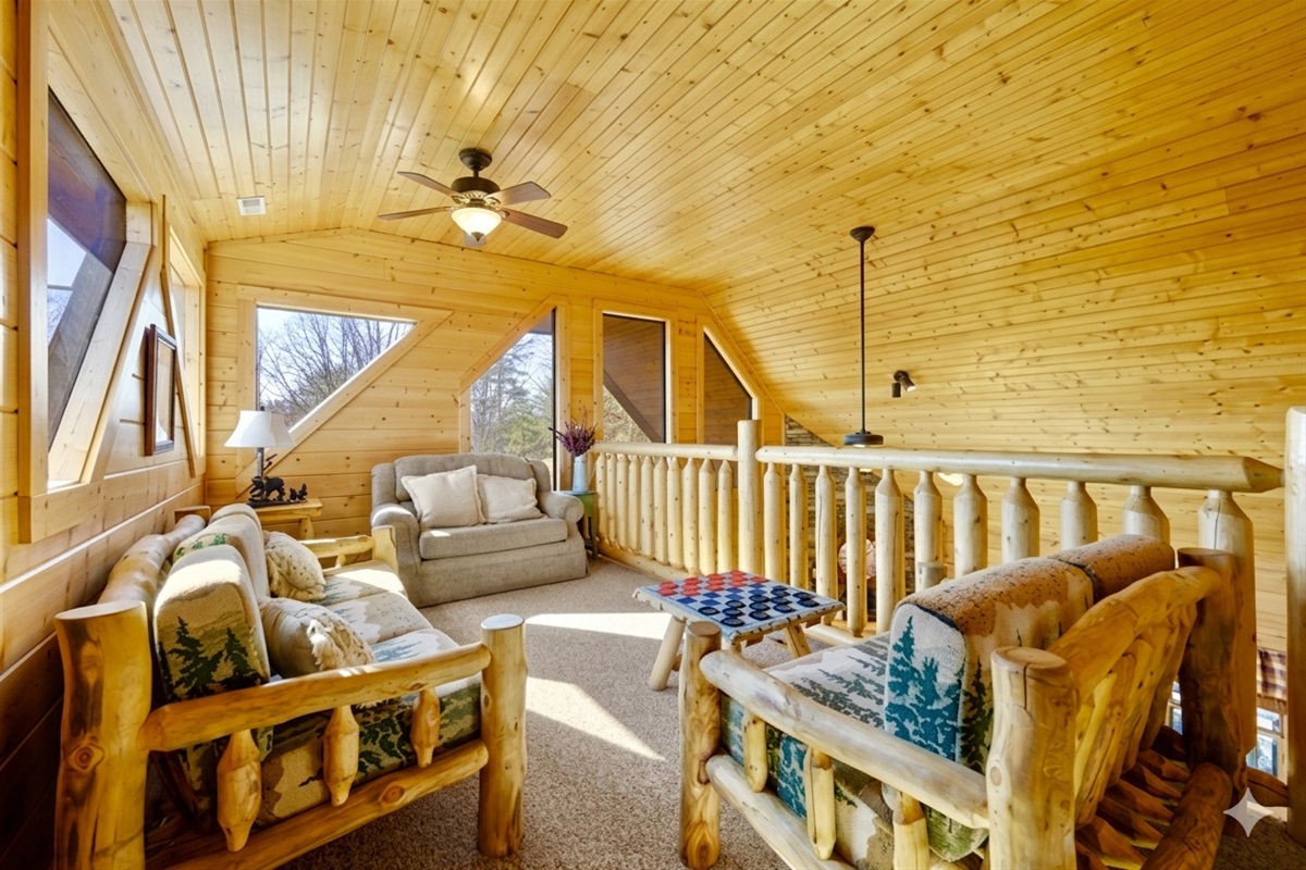 Perched high above the treetops, this cozy loft invites you to unwind with a good book or a friendly game. Soft light filters through the windows, creating a peaceful mountain retreat for everyone to gather.